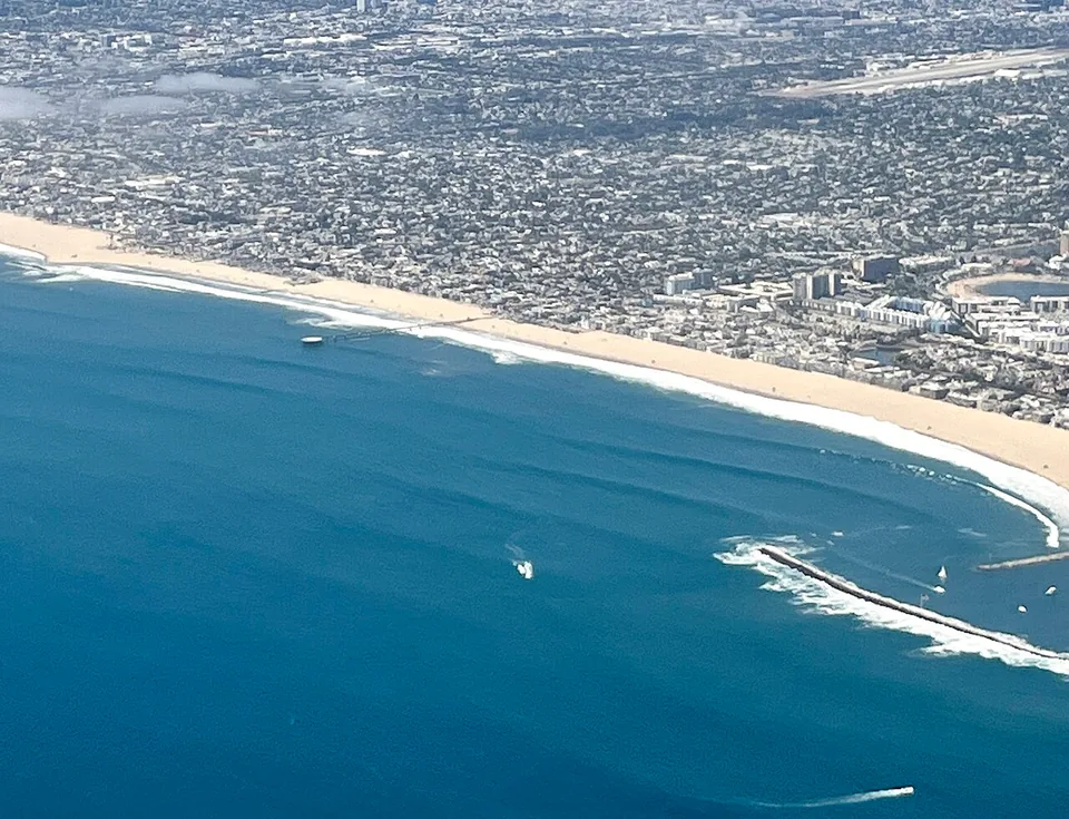Aerial view of Venice Beach, with the Pacific Ocean meeting the broad sandy shore and city